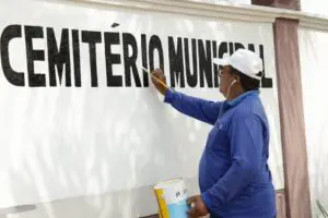 Foto de uma pessoa pintando a parede.