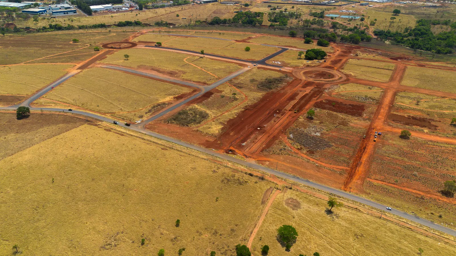 Imagem aérea das obras do Dianot em Aparecida, mostrando ruas asfaltadas, rotatórias em construção e terrenos preparados, destacando o avanço na infraestrutura do novo polo agroindustrial.