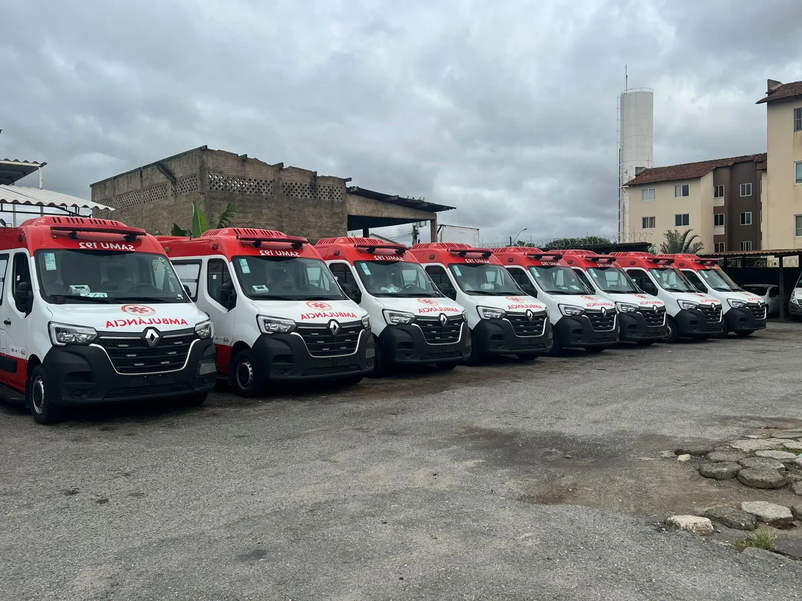 A imagem mostra ambulâncias novas do Samu alinhadas em um pátio, destacando a renovação da frota com veículos Renault Master nas cores branca e vermelha.