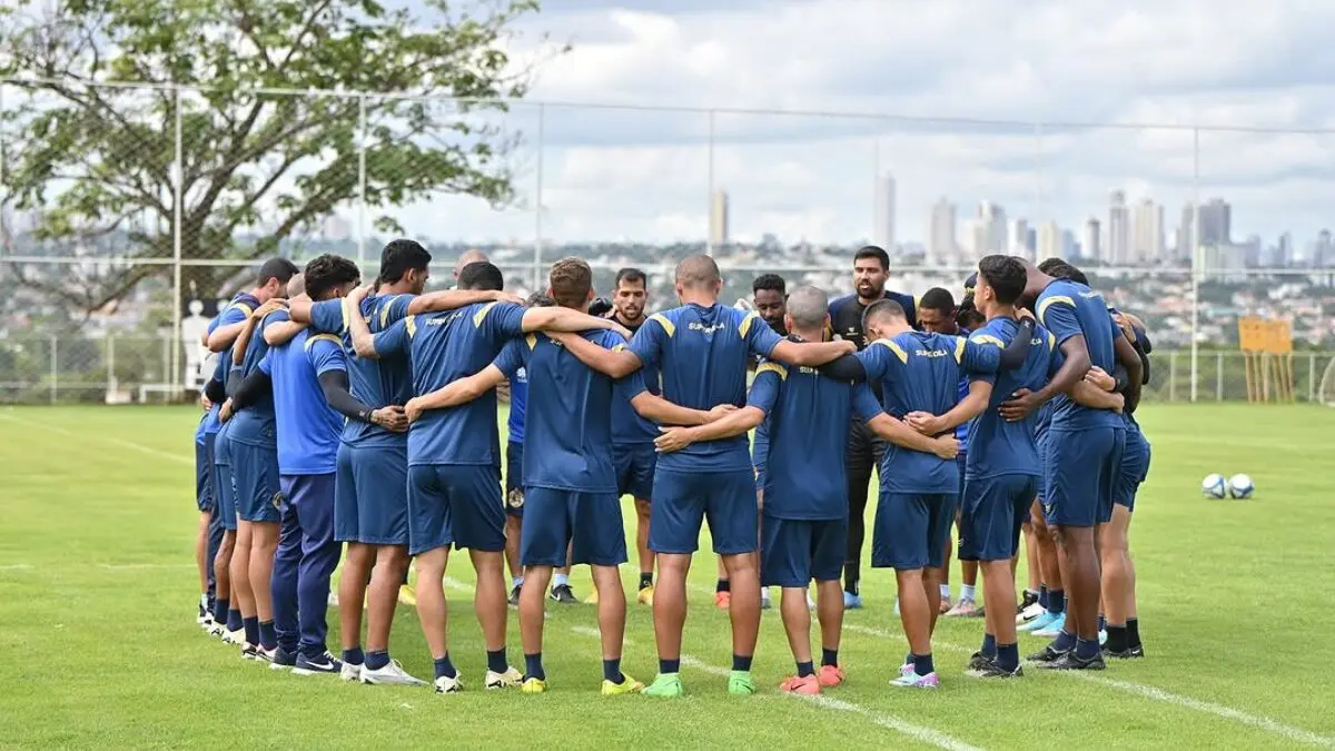 Reunião dos jogadores no gramado durante uma preleção coletiva antes de um treinamento.