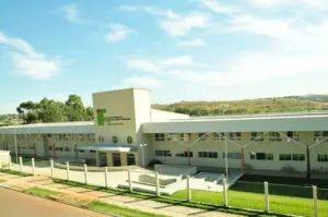 Fachada do Instituto Federal de Goiás (IFG), com arquitetura moderna, cercada por gramados e localizada em uma área tranquila com paisagem de colinas ao fundo.