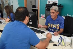 Fotos de dois homens em uma mesa conversando.