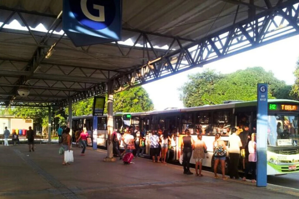 Terminal Cruzeiro, em Aparecida de Goiânia, com passageiros embarcando e desembarcando de ônibus em um ambiente movimentado.