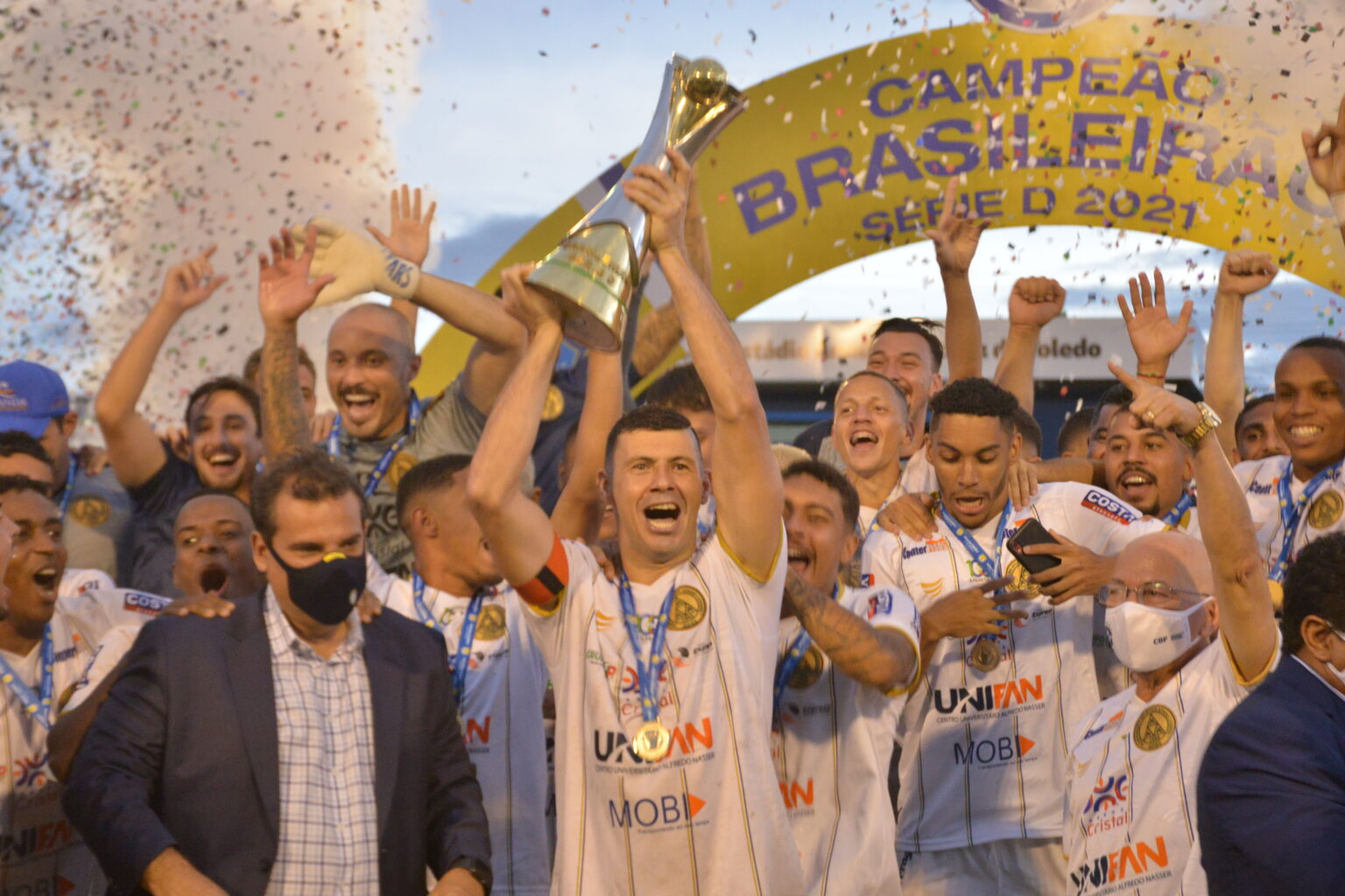 Grupo de jogadores celebrando a conquista de um campeonato de futebol.